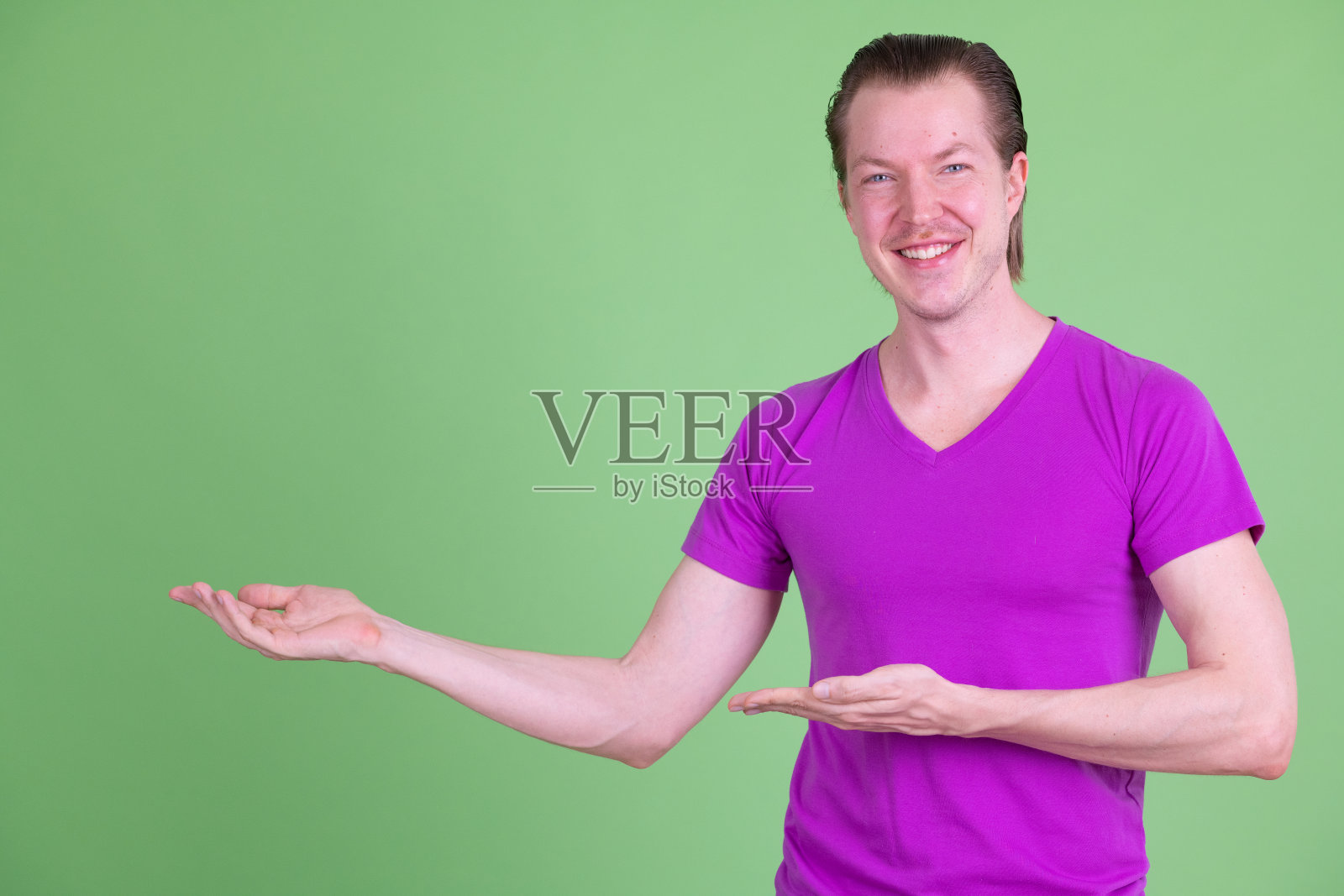 展示某物的快乐年轻英俊男子照片摄影图片