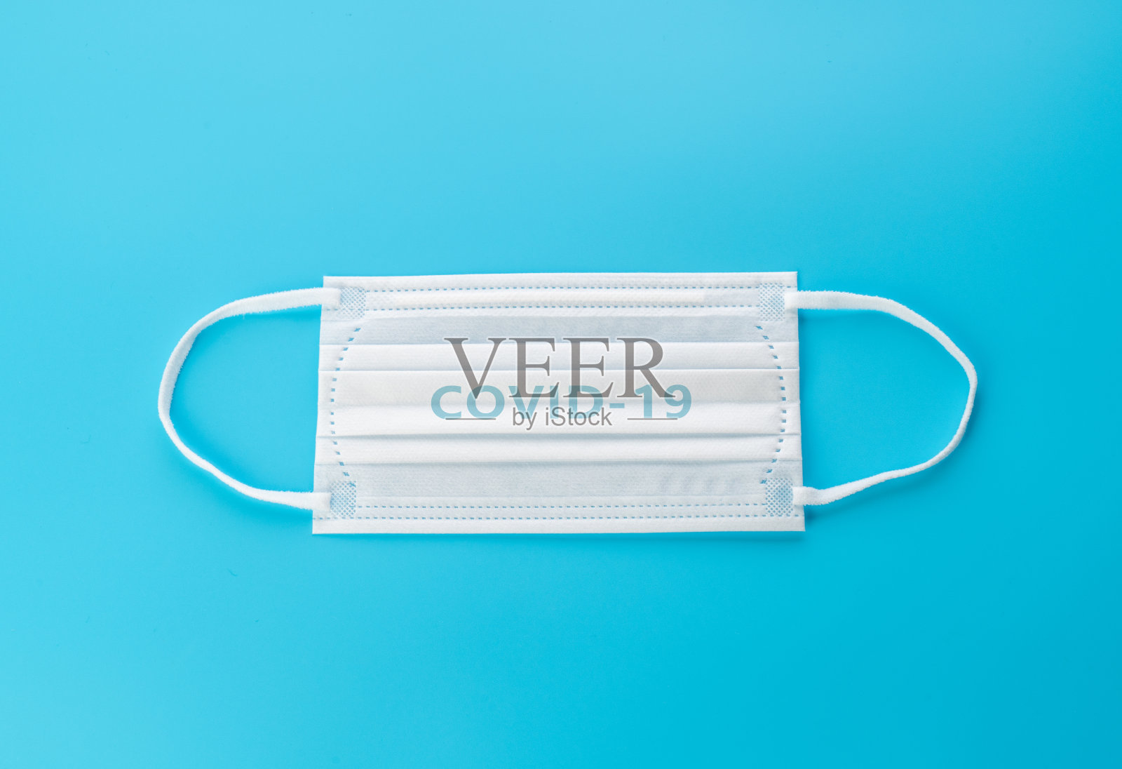 蓝色背景的白色外科口罩照片摄影图片