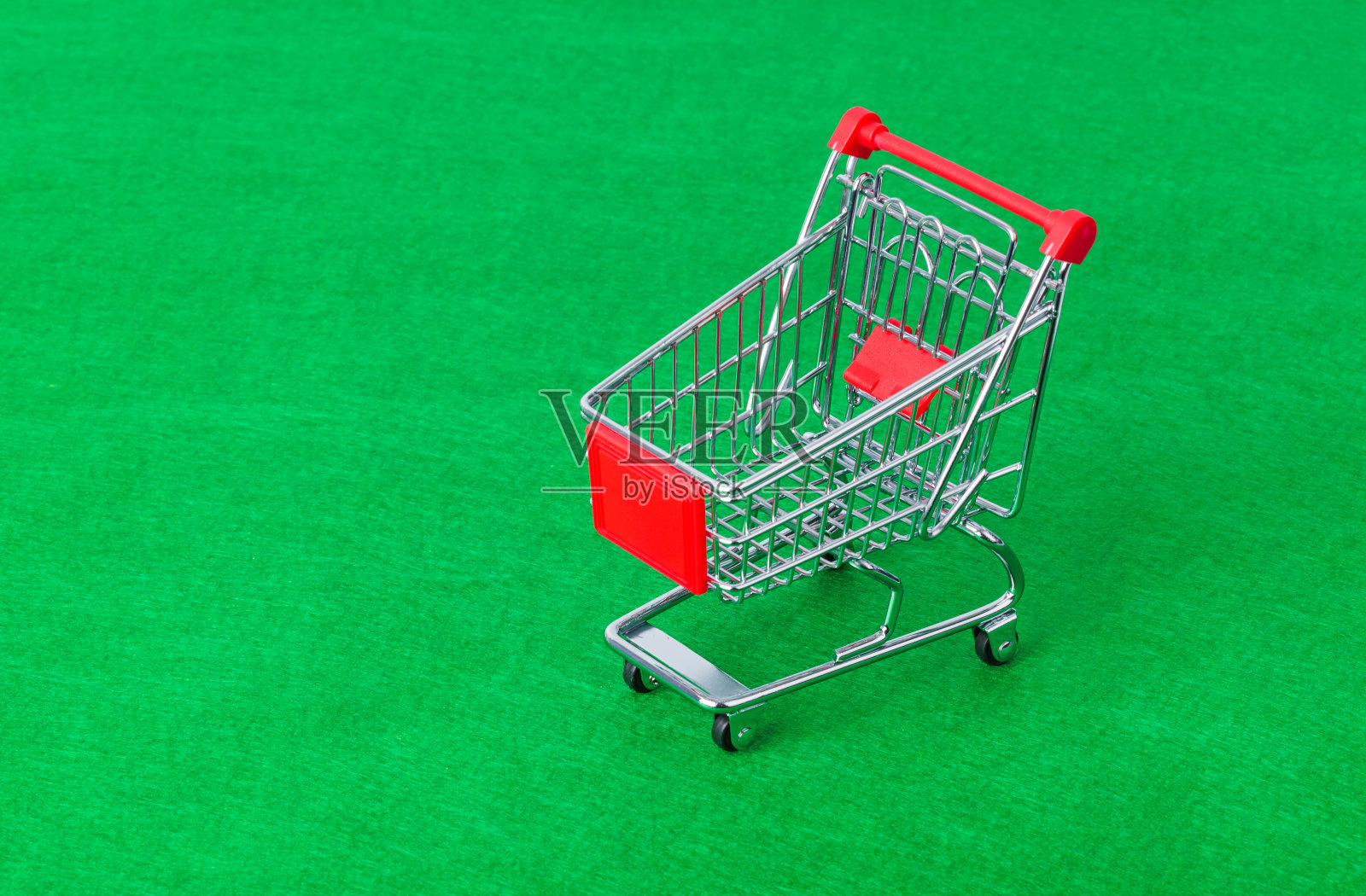 玩具购物车在绿色上照片摄影图片
