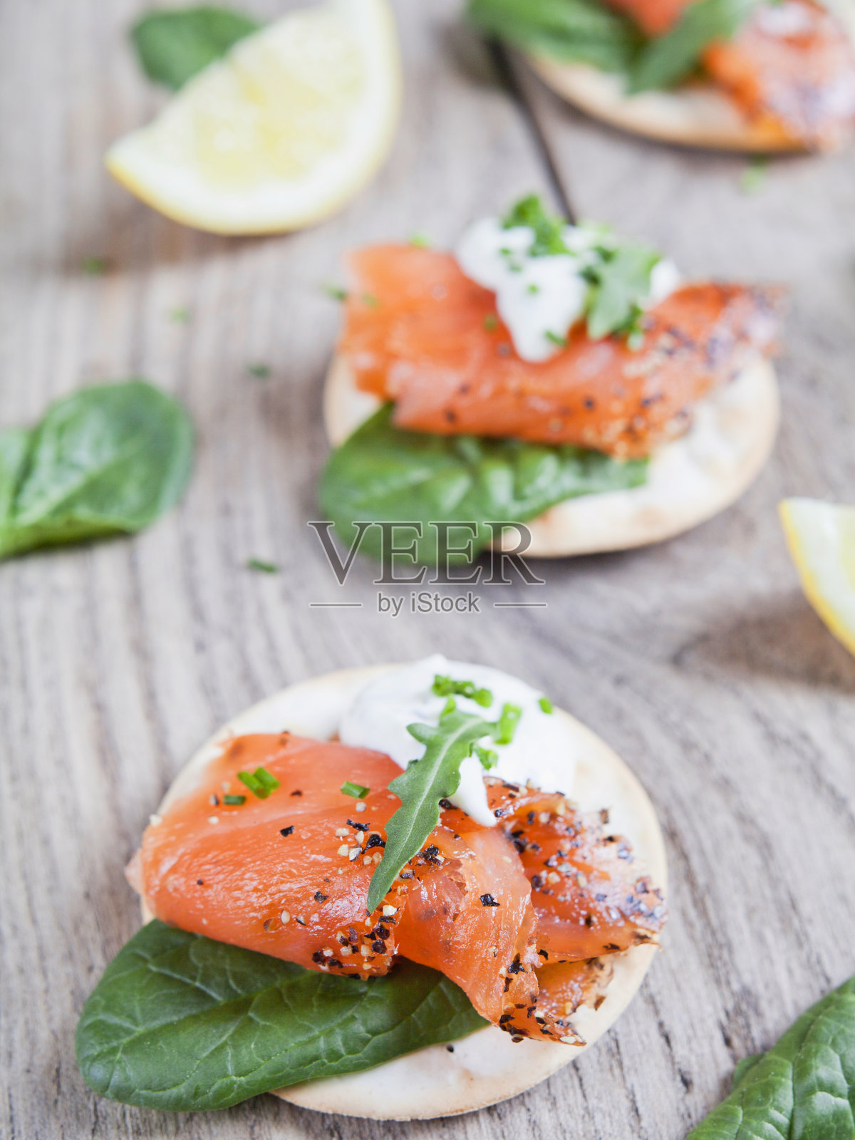 熏鲑鱼开胃菜-美味的鱼，黑胡椒，奶油芝士，绿色配菜。照片摄影图片