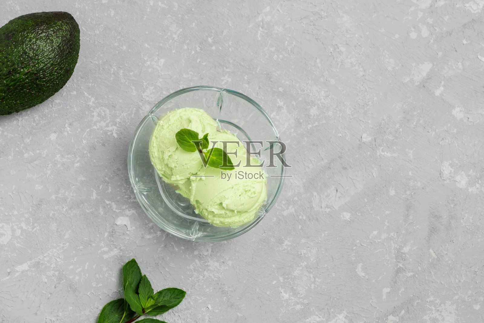 顶视图的健康素食鳄梨冰淇淋与薄荷叶在灰色的背景。带有拷贝空间的图像，俯视图照片摄影图片