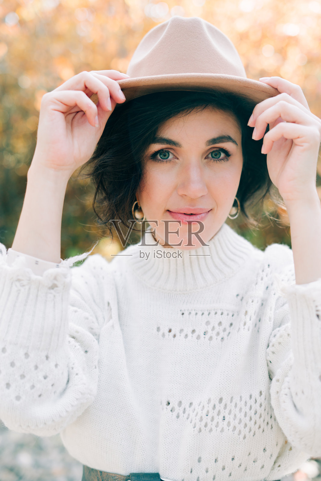 穿白色连衣裙戴帽子的年轻女孩在秋日森林中嬉戏人像照片摄影图片