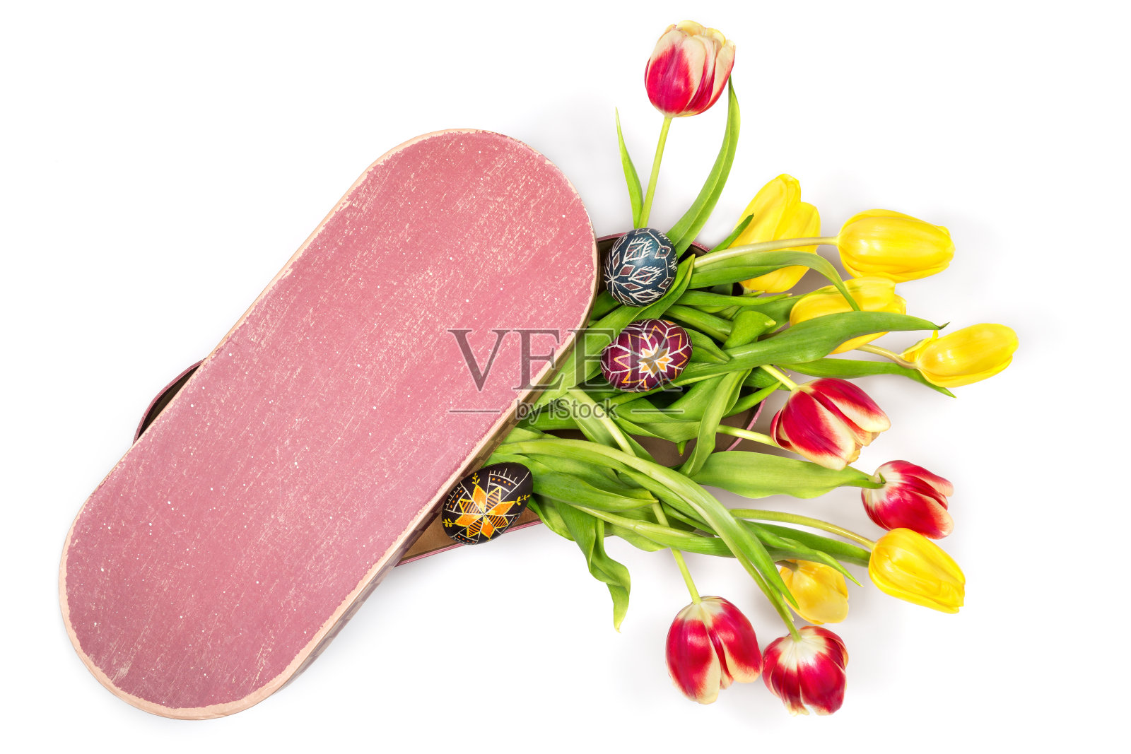 一束漂亮的黄色和红色的郁金香和手绘复活节彩蛋在椭圆形的盒子。在方框的顶部留出文本空间照片摄影图片