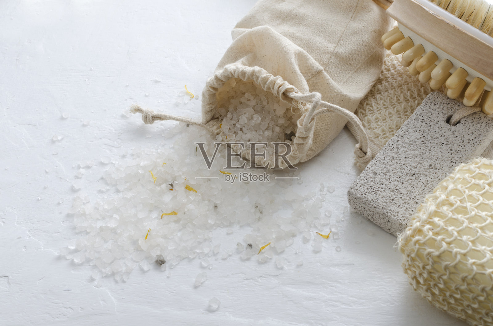 布袋的海盐，海绵，浮石的脚在白色的表面。水疗沙龙的桌子和身体护理配件照片摄影图片