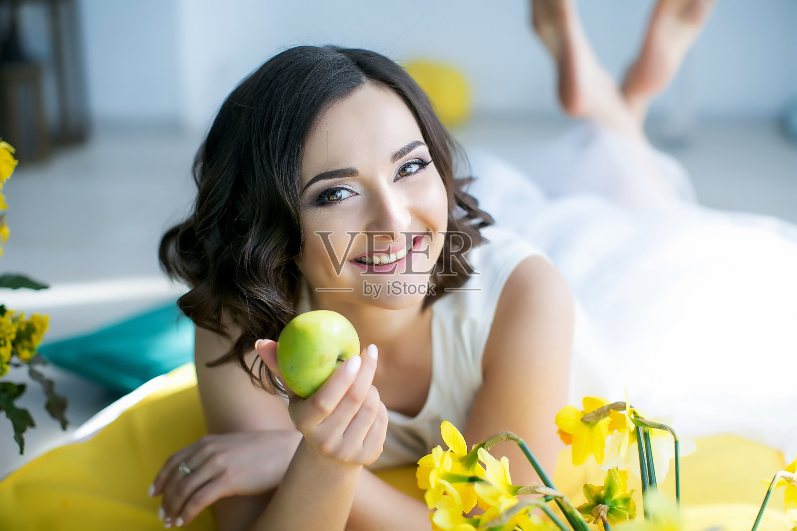 一个穿着白色衣服的女人站在门口，背景是鲜艳的黄色花朵照片摄影图片