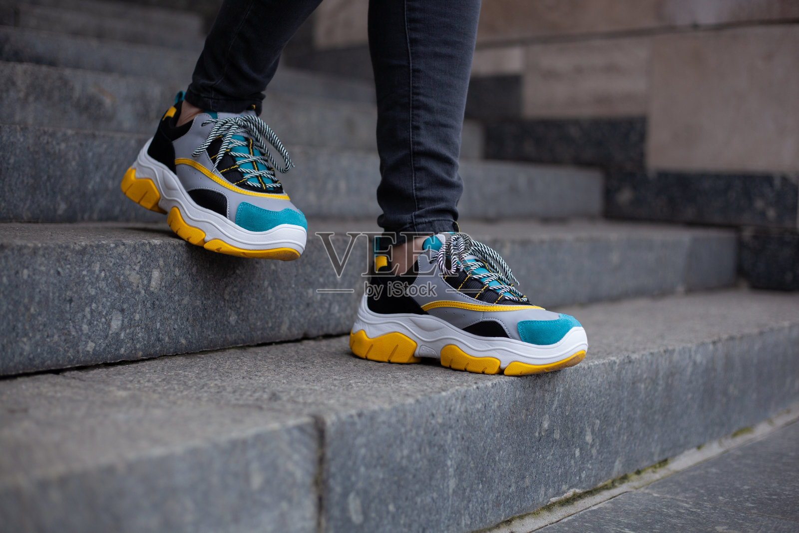 脚蹬黄、白、黑、蓝等多种颜色的运动鞋，走下大理石楼梯照片摄影图片