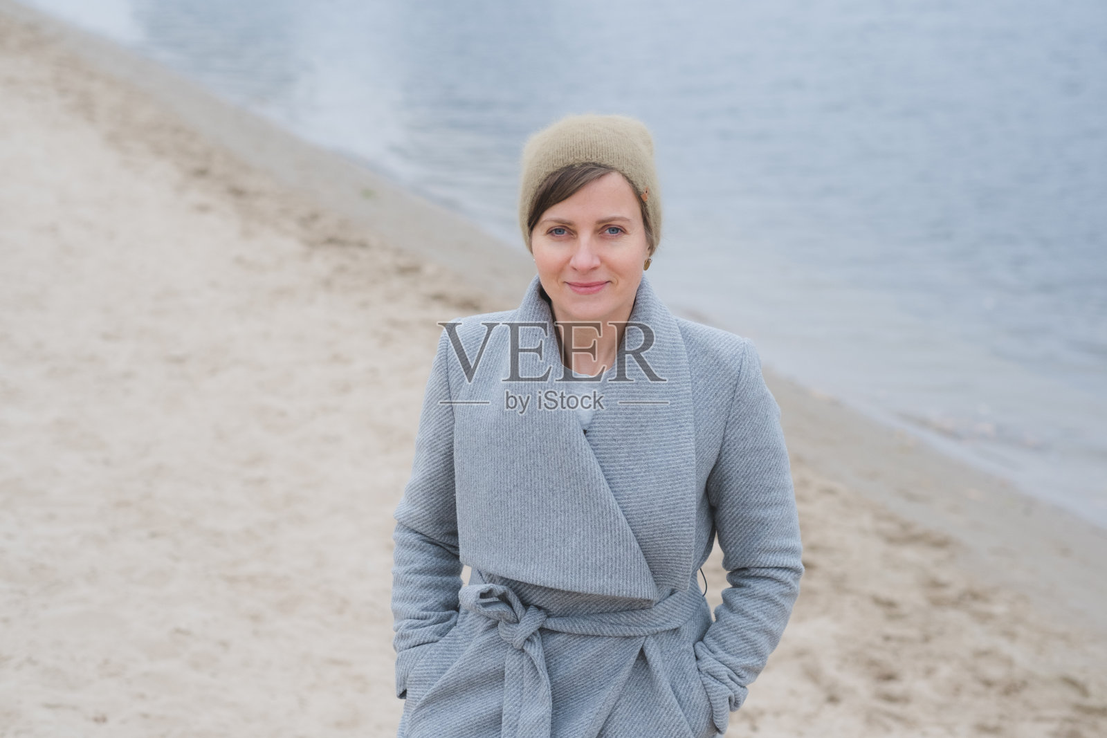 年轻女子穿着灰色外套独自走开照片摄影图片