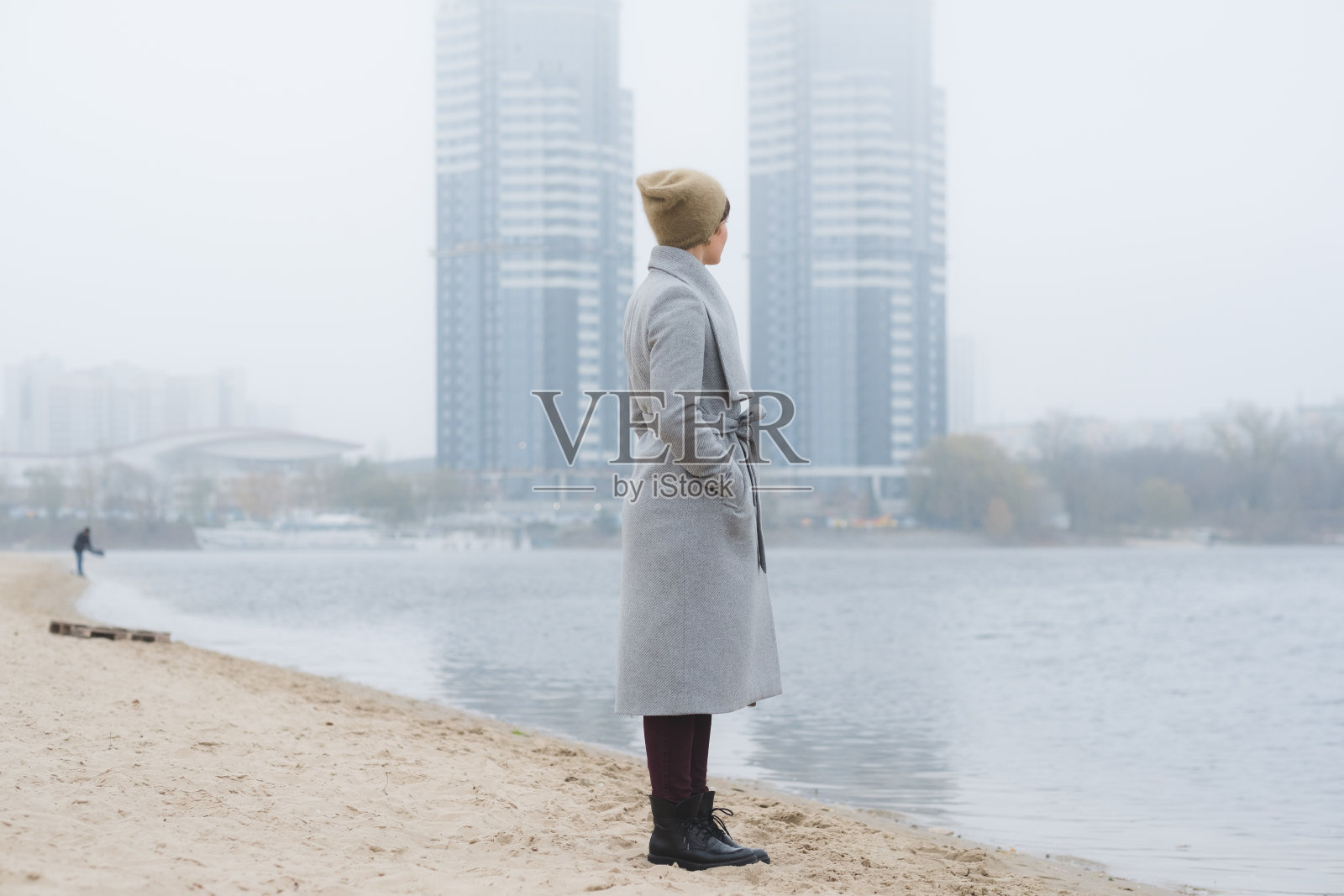 年轻女子穿着灰色外套独自走开照片摄影图片