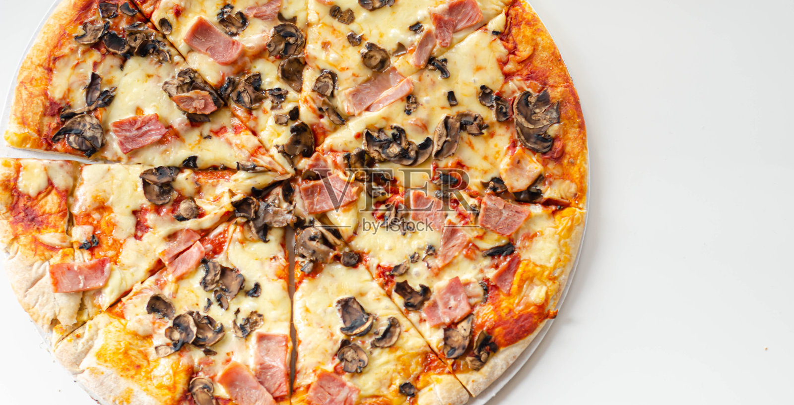 新鲜出炉的大披萨配上火腿、蘑菇和马苏里拉奶酪照片摄影图片