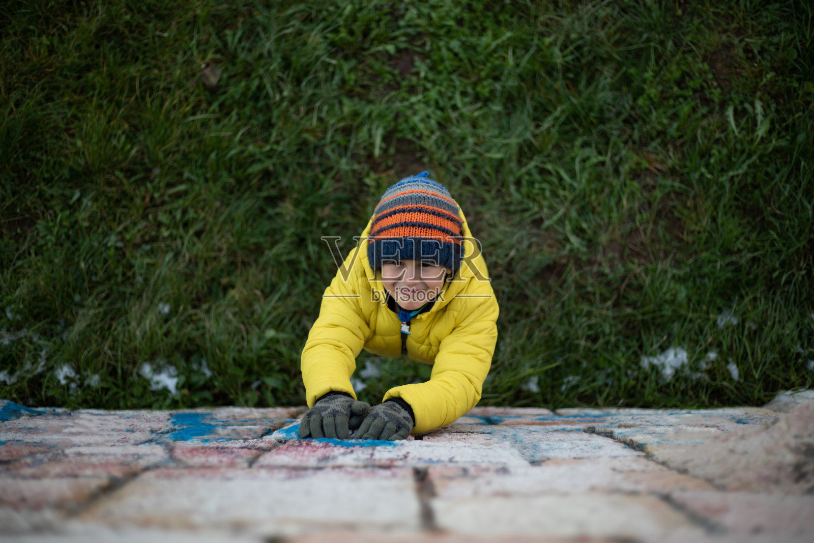 学龄前的男孩站在草地上看着相机上面的库存照片照片摄影图片