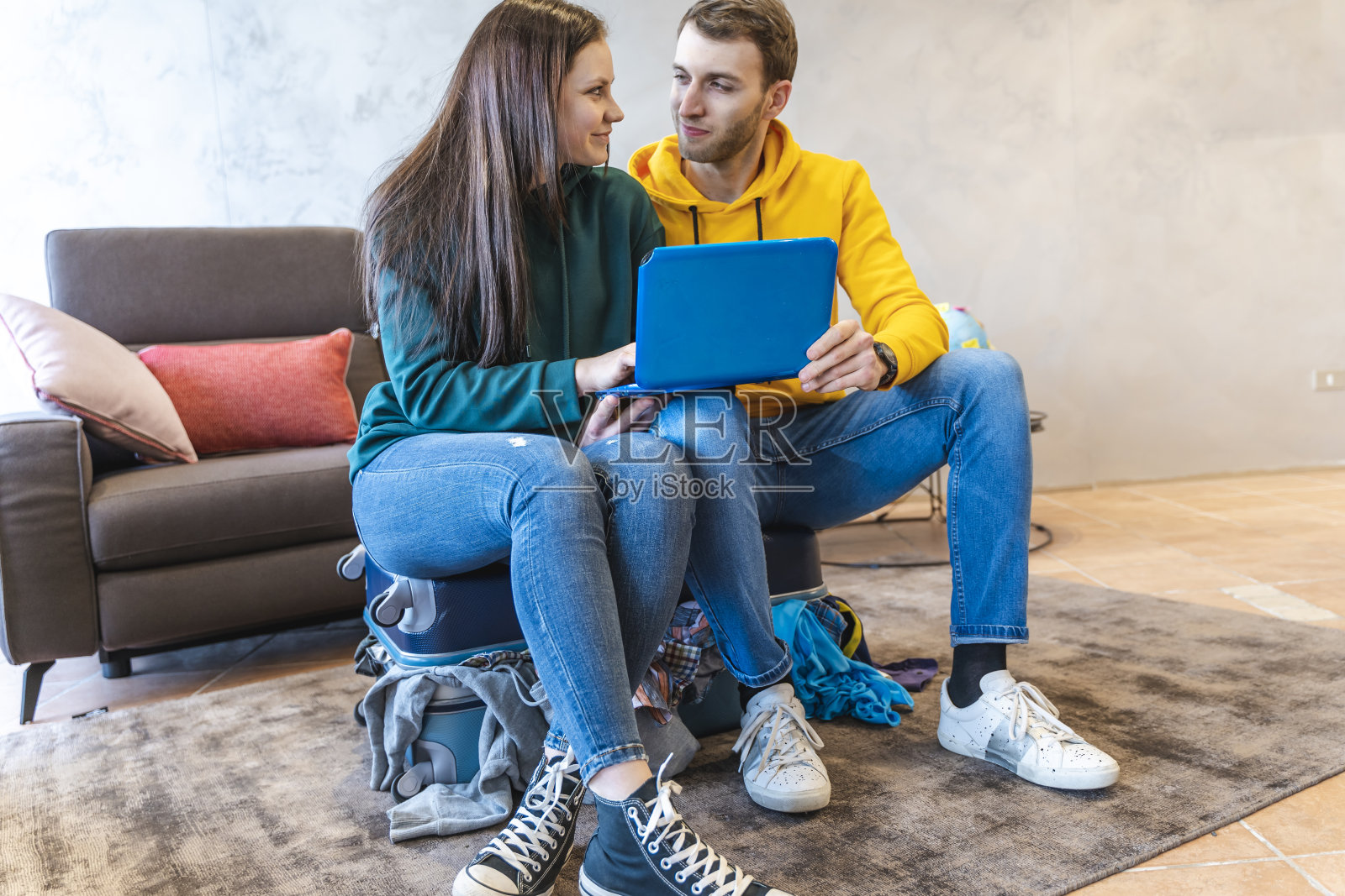 一对年轻夫妇坐在行李箱上照片摄影图片