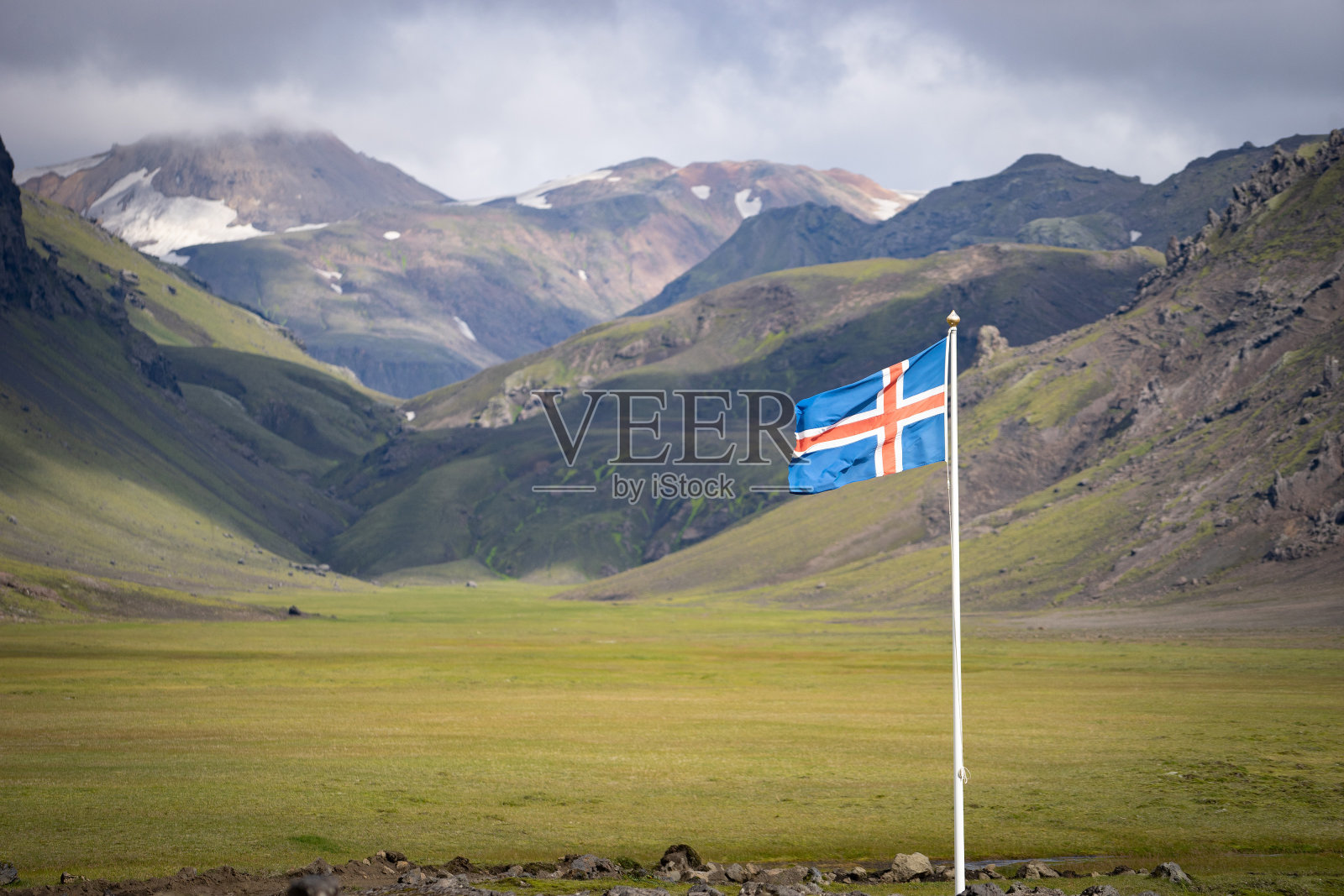 以青山和蓝天为背景的冰岛国旗照片摄影图片