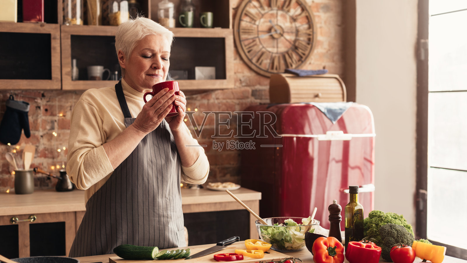 老年妇女在厨房里放松地享用热咖啡照片摄影图片