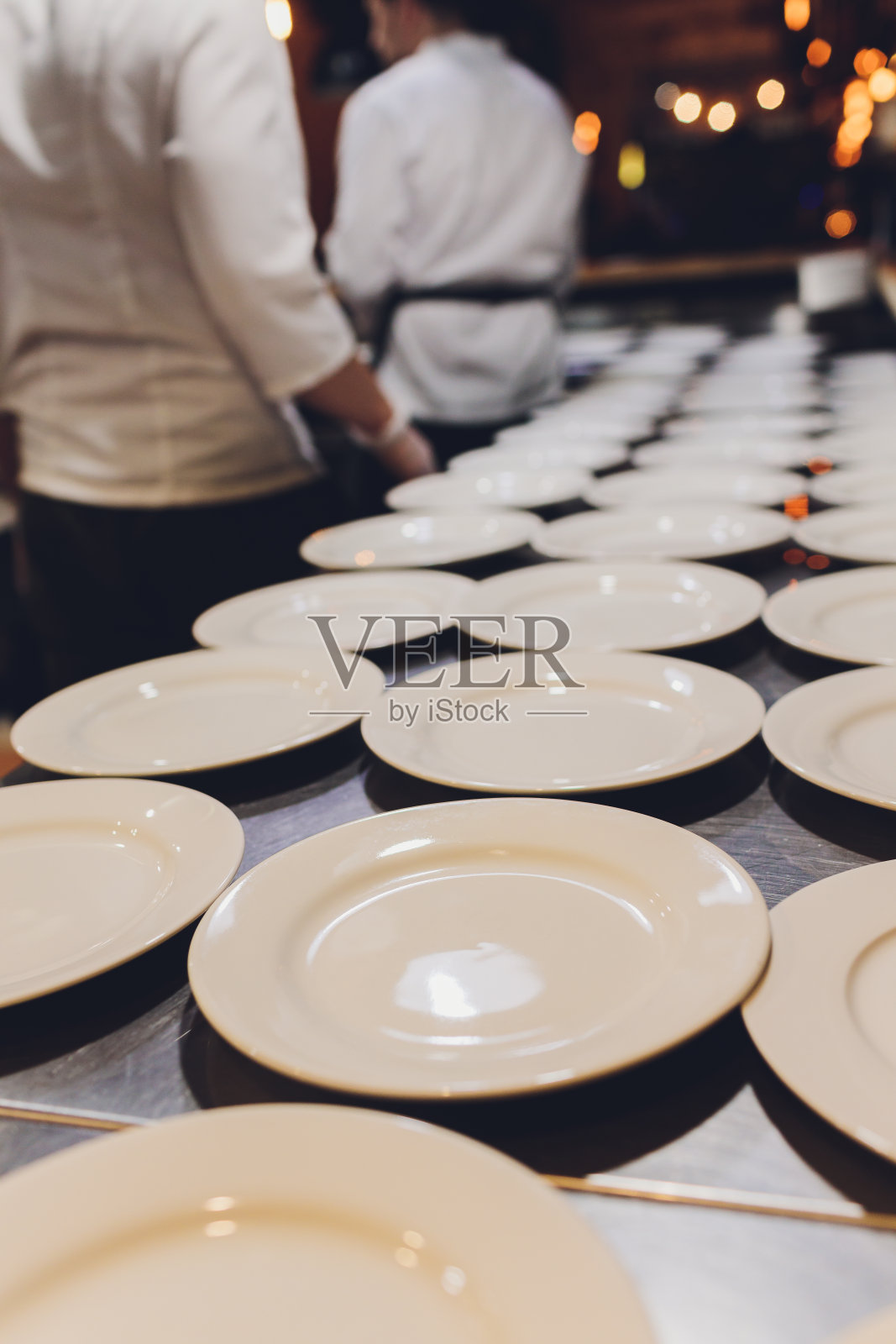 桌子上放着许多白色的陶瓷器皿。陶器的背景。照片摄影图片