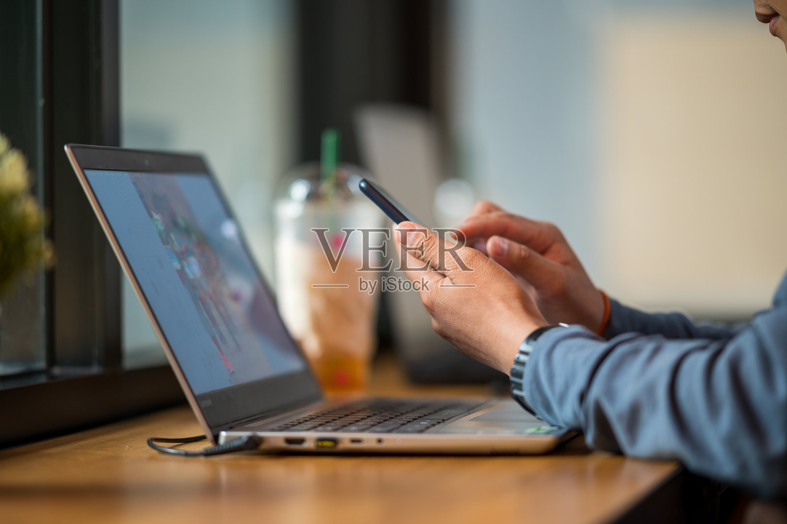 商务男人手持手机办公桌特写照片摄影图片