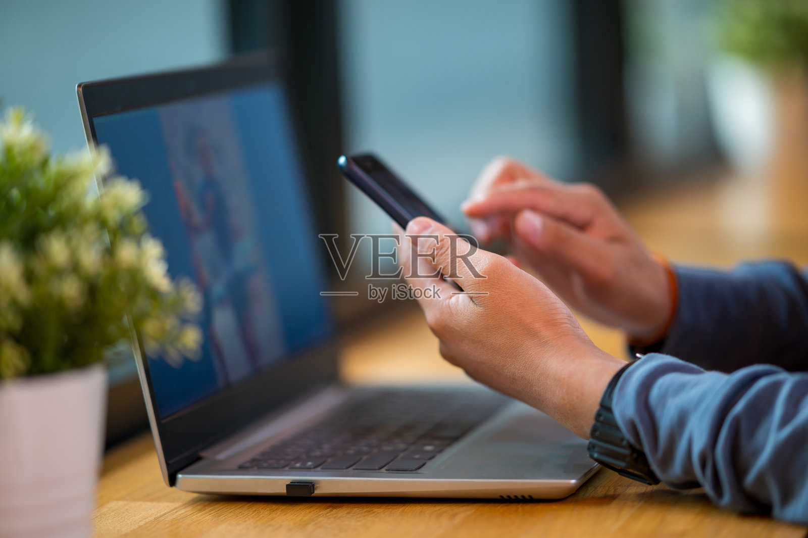 商务男人手持手机办公桌特写照片摄影图片