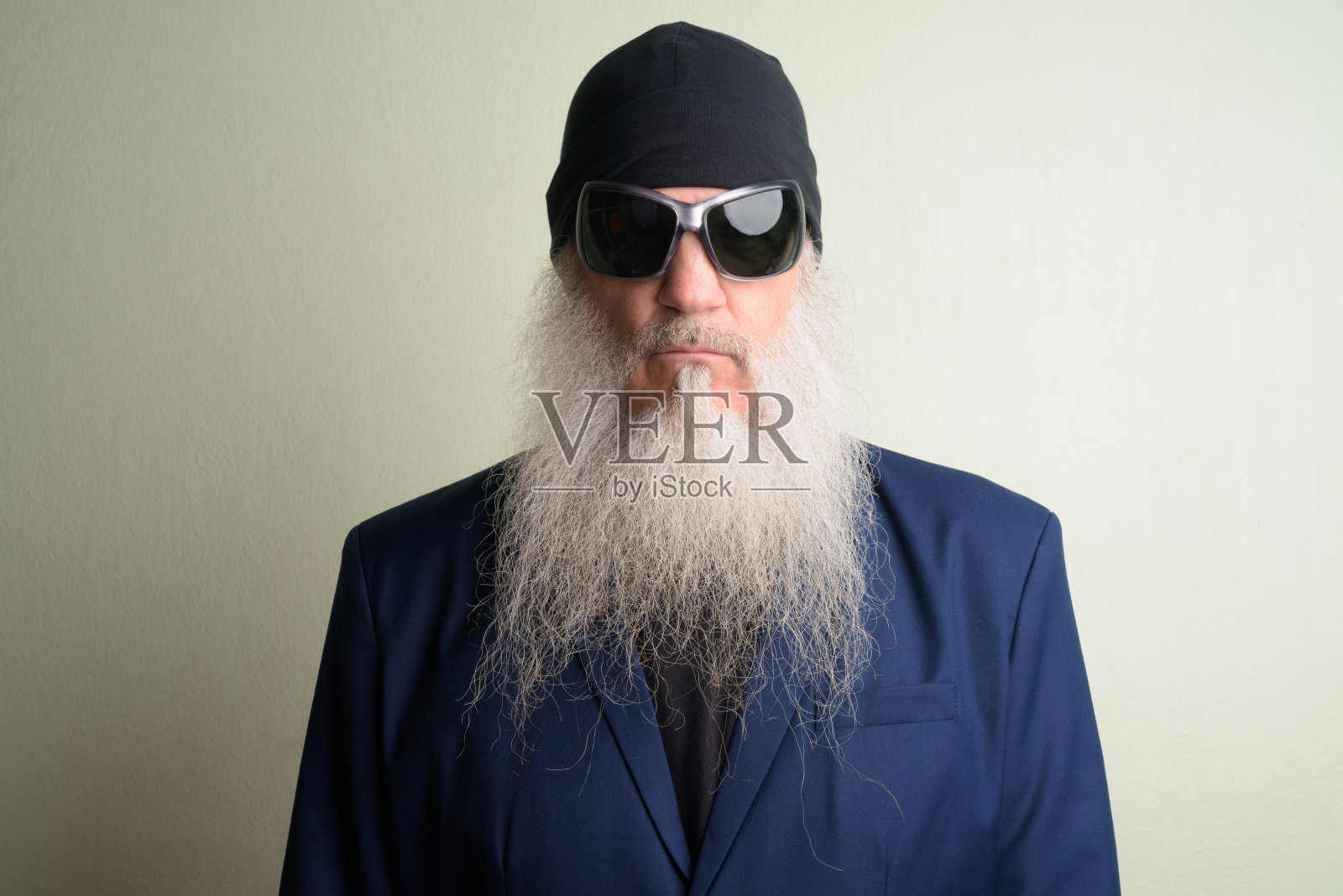 成熟的胡子商人的脸，穿着西装，戴着太阳镜和无檐帽照片摄影图片