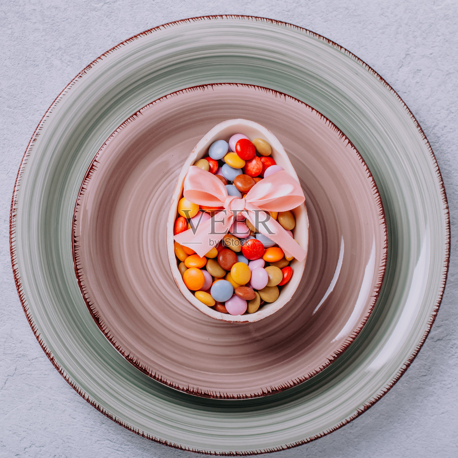 盘子与复活节巧克力蛋和彩色糖果，餐桌设置复活节，最小的概念，俯视图照片摄影图片