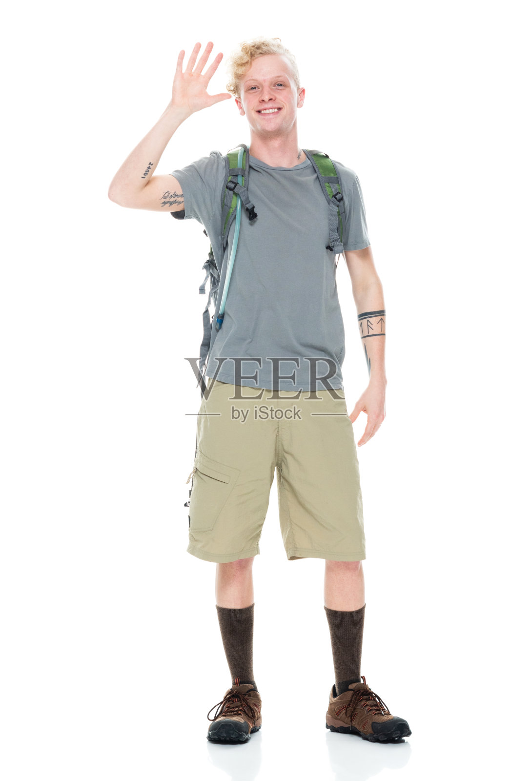 白人男性背包客徒步旅行在前面的白色背景穿着短裤和拿着包照片摄影图片