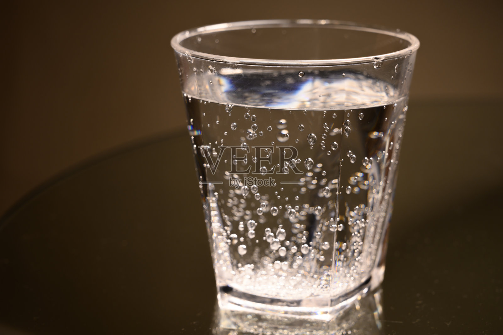 透明的塑料玻璃，上面有起泡的水照片摄影图片