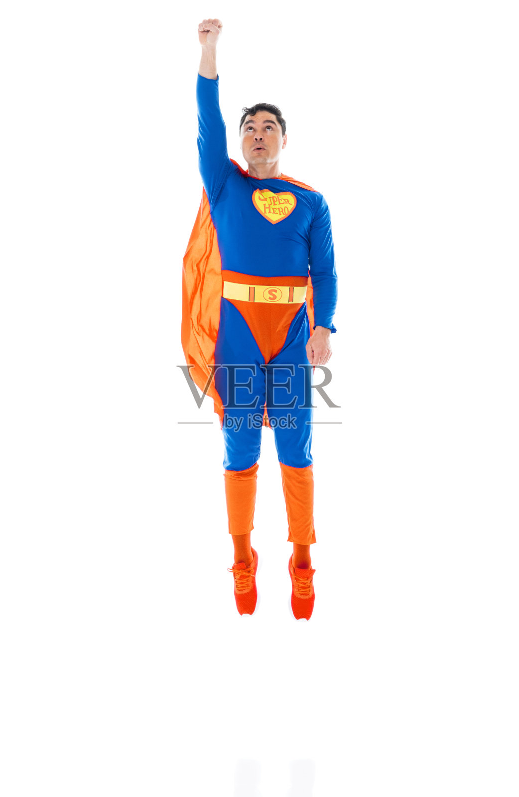 身穿斗篷、在白色背景前飞翔的白人英雄照片摄影图片