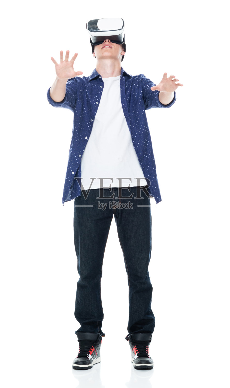 穿着衬衫在白色背景前使用AR的白人少年照片摄影图片