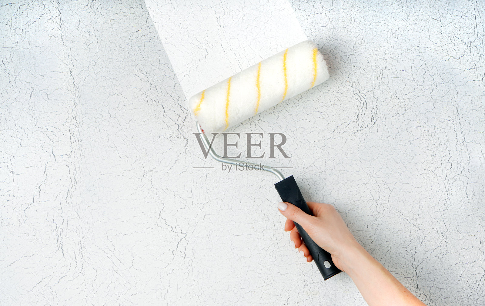 墙壁绘画背景，家居重新装修概念，女性手持油漆滚筒，留白照片摄影图片