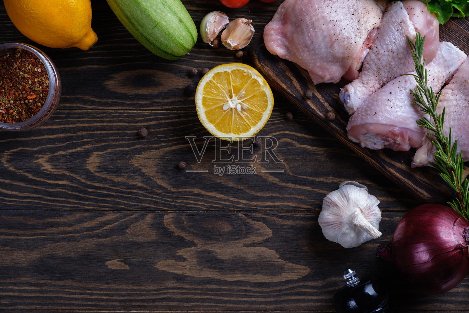 新鲜的生鸡腿和鸡腿放在木板上，配上香料和香草放在木桌上照片摄影图片