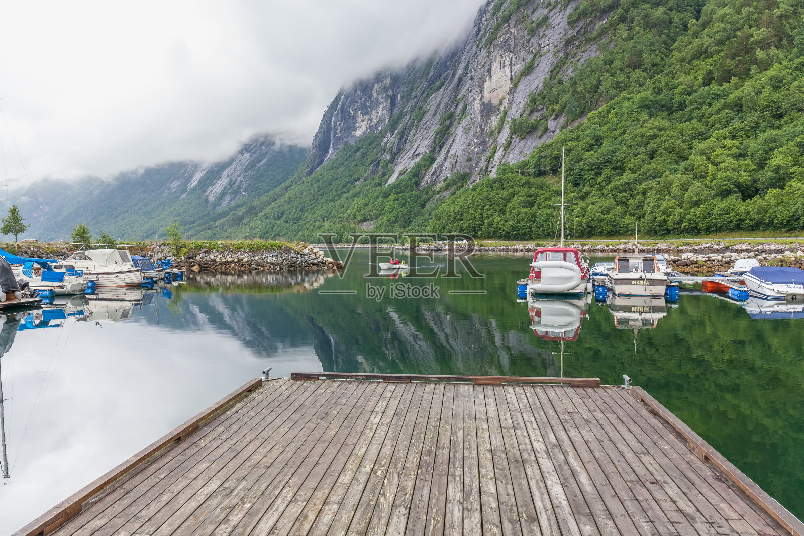 Molde，挪威- 2016年6月7日:码头，渔船与水的倒影，山在挪威的背景照片摄影图片