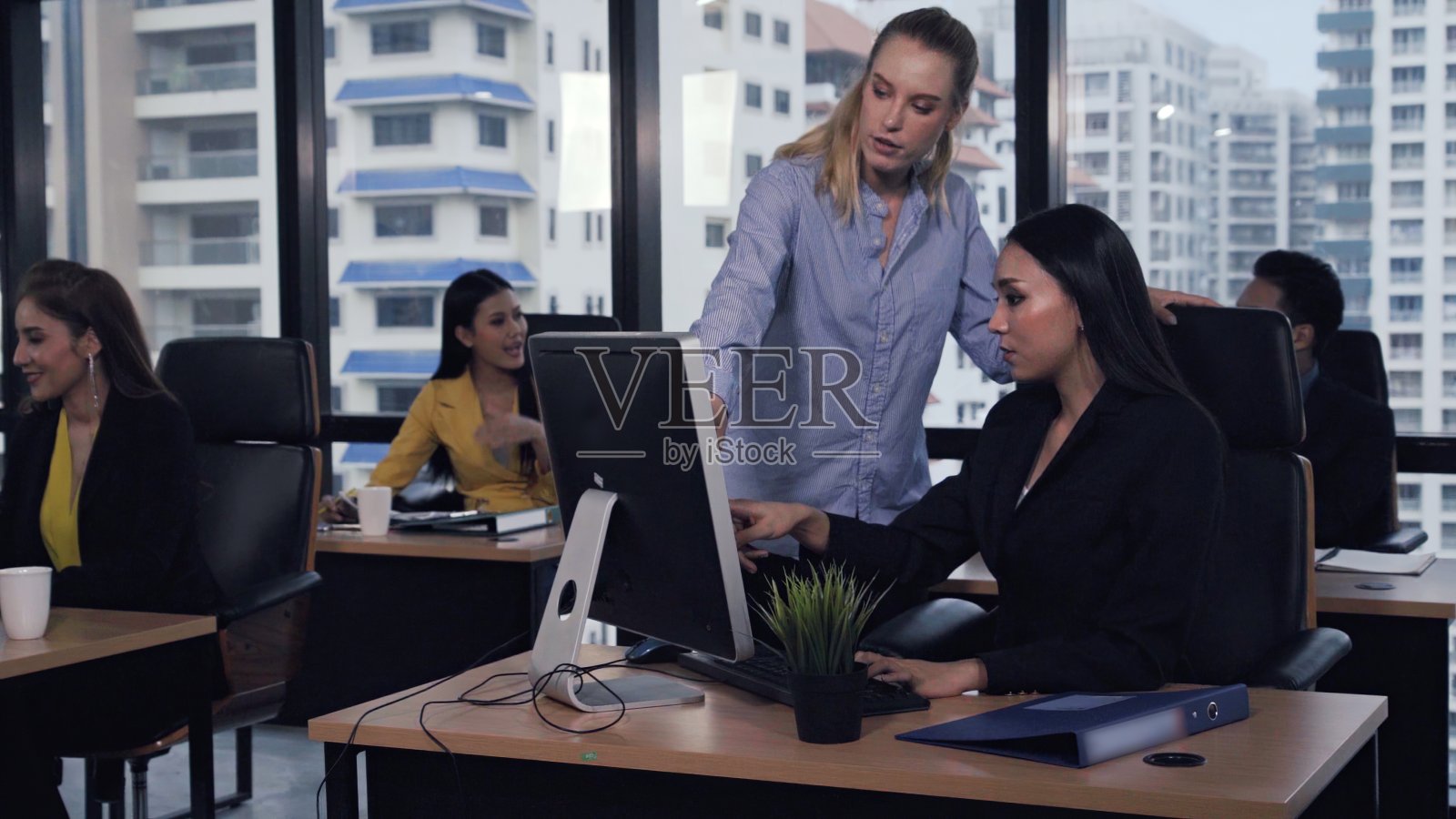 年轻的领导者向年轻的女工人提供建议。照片摄影图片