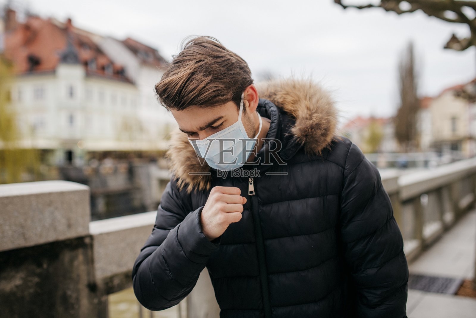 年轻男子戴口罩咳嗽照片摄影图片