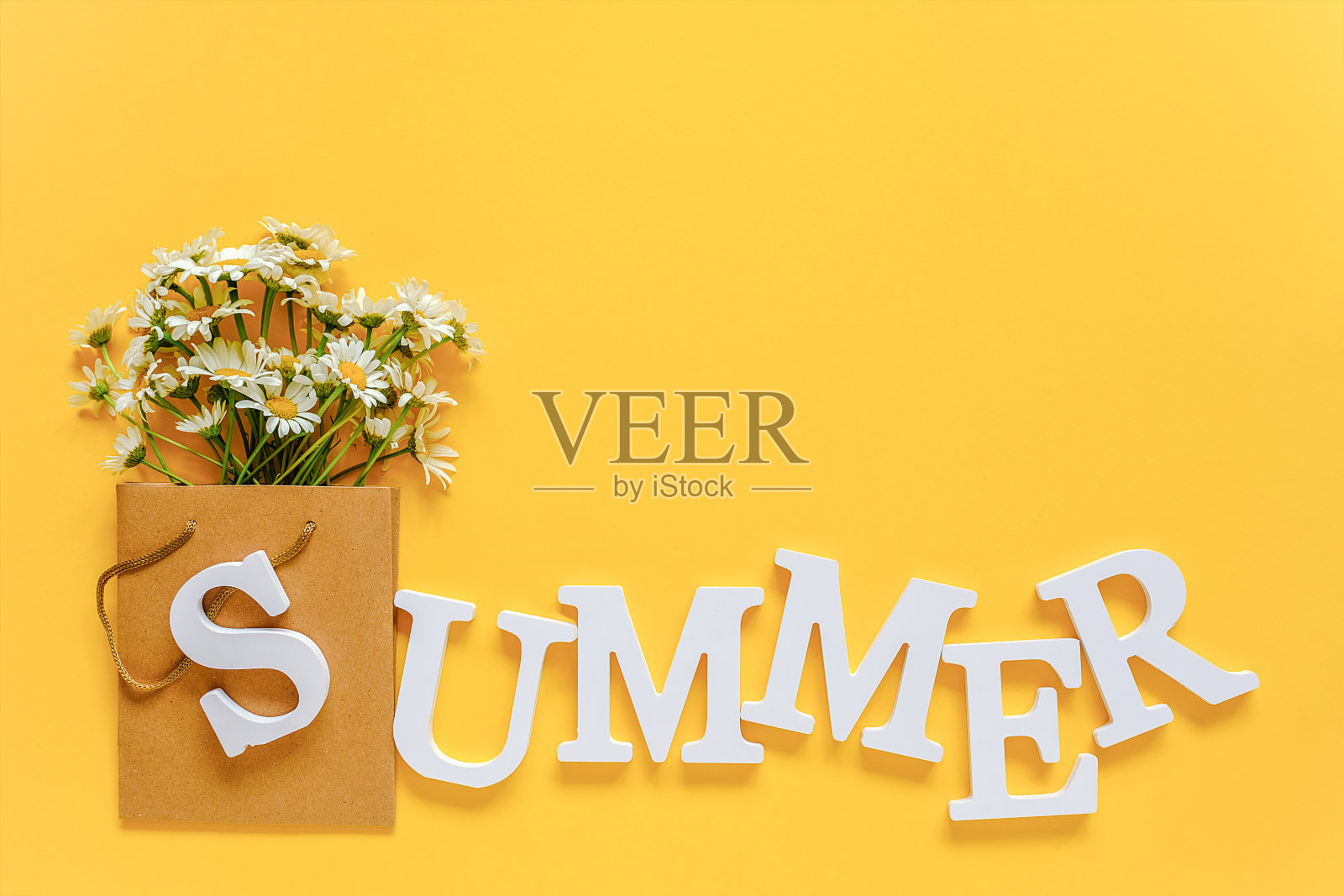 文字夏天从白色卷信和田野洋甘菊花在工艺包装在黄色的背景。贺卡平铺拷贝空间概念你好夏季，夏季时间照片摄影图片