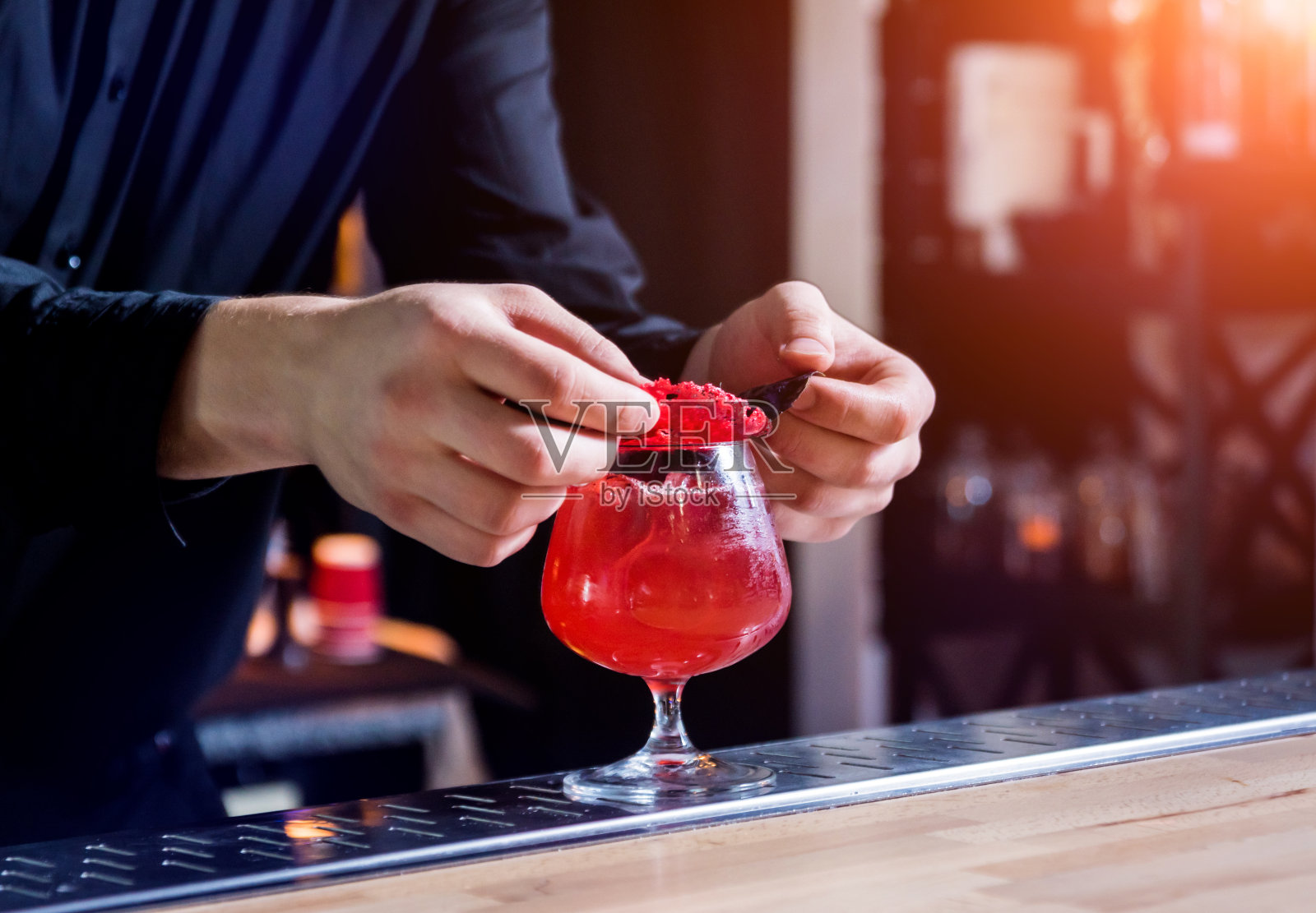 调酒师正在吧台做鸡尾酒。新鲜的鸡尾酒。酒吧间招待员。照片摄影图片