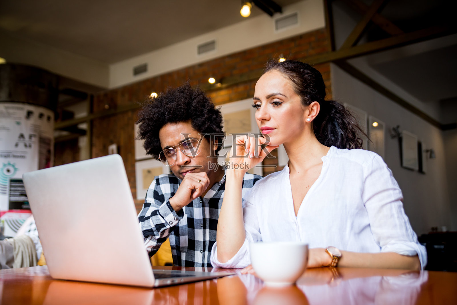 在咖啡馆开会的多种族商业团队，使用笔记本电脑工作照片摄影图片