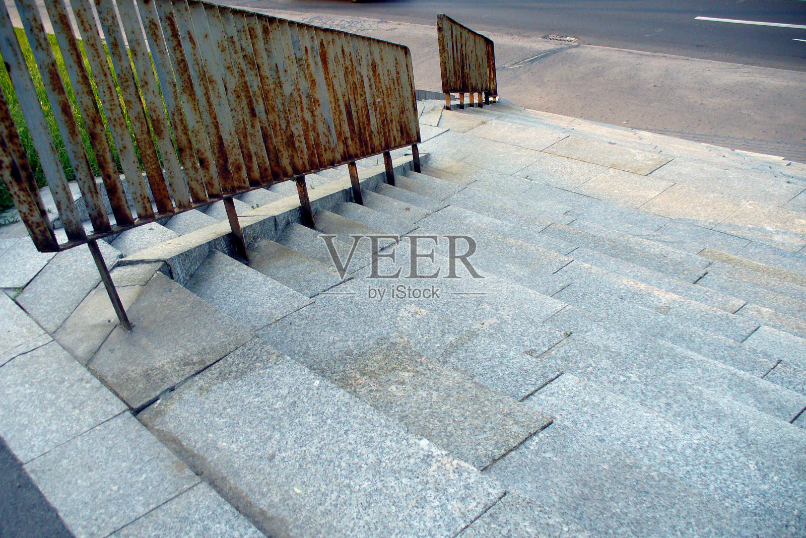 街道左侧的生锈旧栏杆和楼梯照片摄影图片