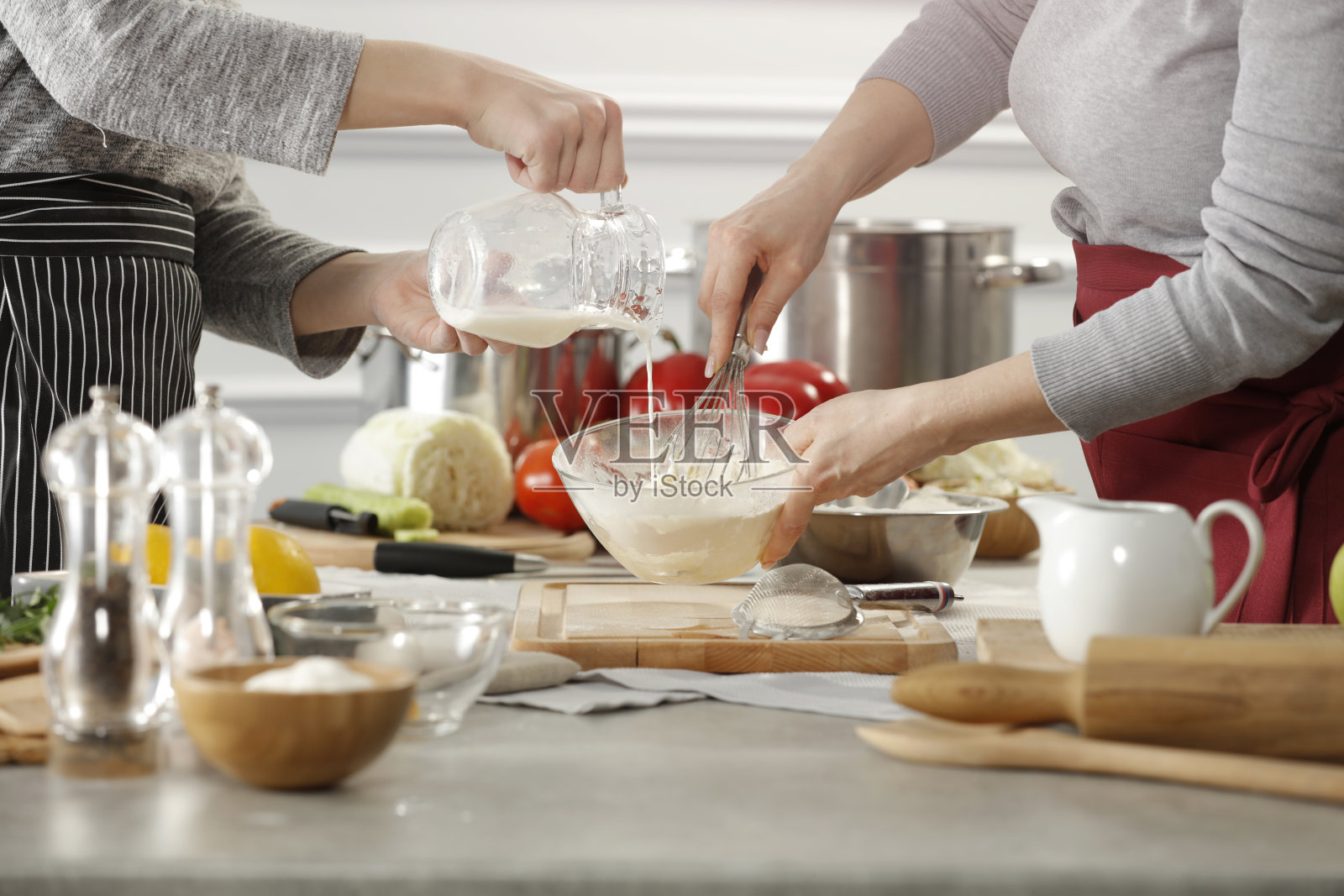 厨师在厨房工作，背景是厨房用具、设备和食品照片摄影图片