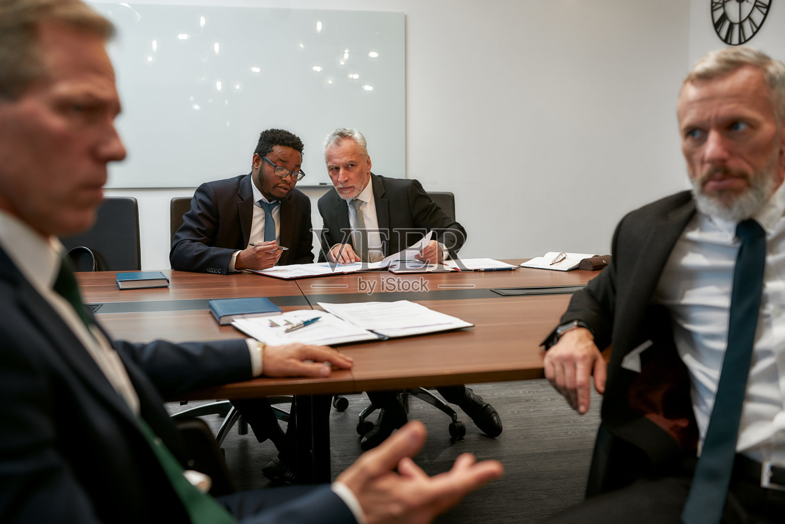 在现代办公室与合作伙伴开会讨论合同条款的商务人士照片摄影图片