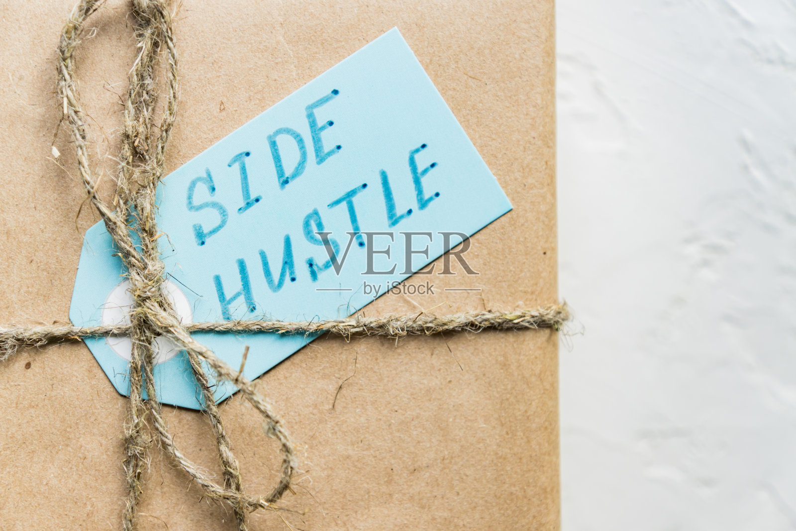蓝色标签上的副业，礼品盒用再生纸包裹照片摄影图片