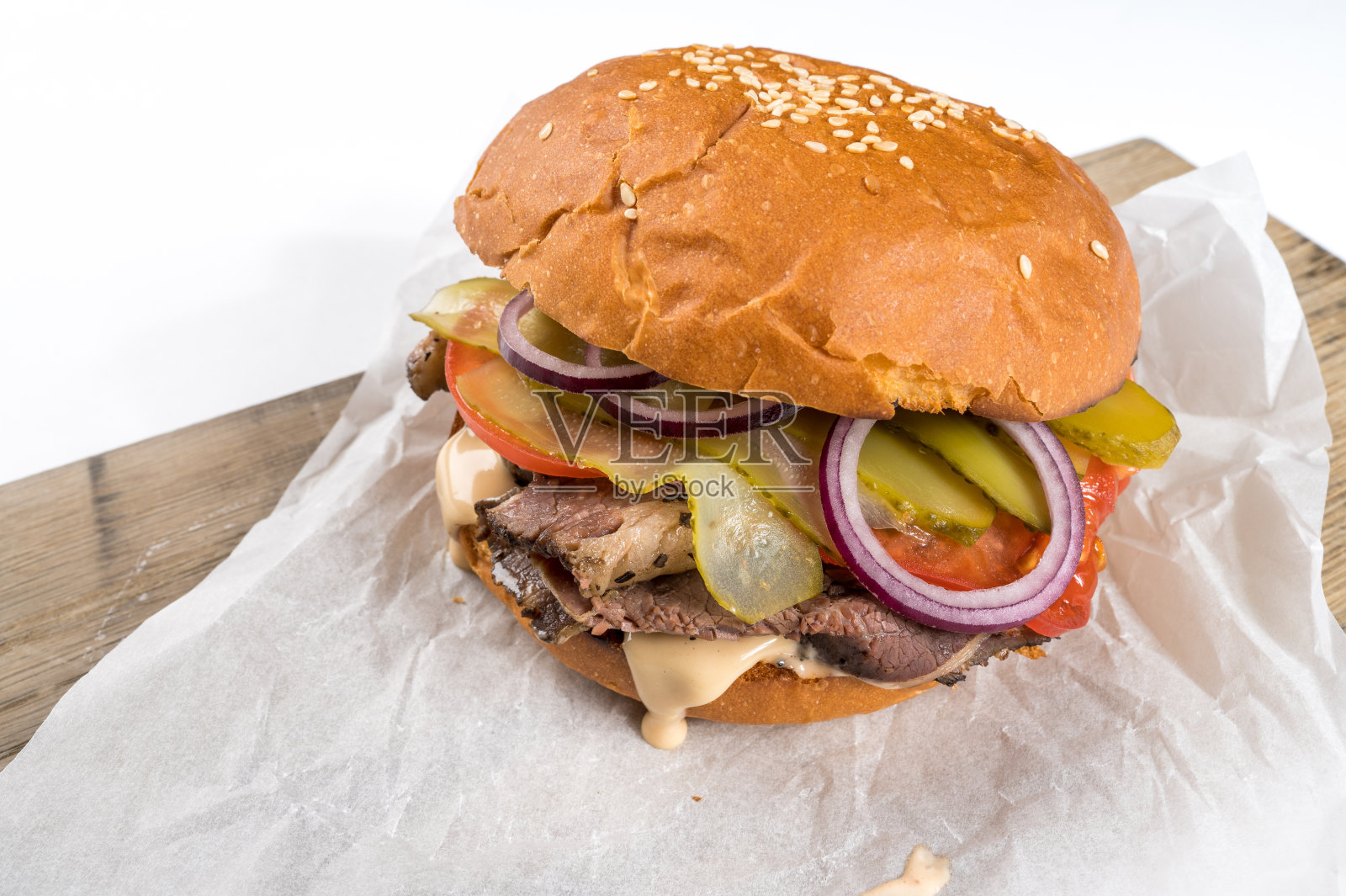 美味的自制汉堡包括小圆面包，奶酪，沙拉，红洋葱和西红柿放在旧木板上照片摄影图片