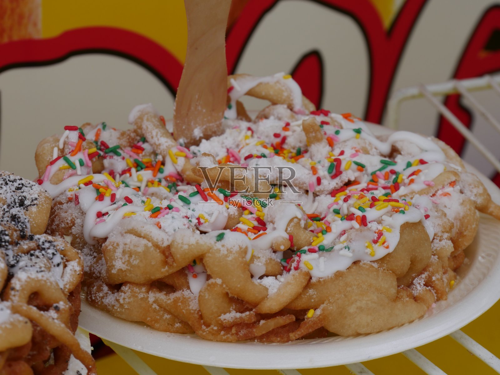 一个生日蛋糕口味的漏斗蛋糕与彩色糖果顶部的特写照片摄影图片