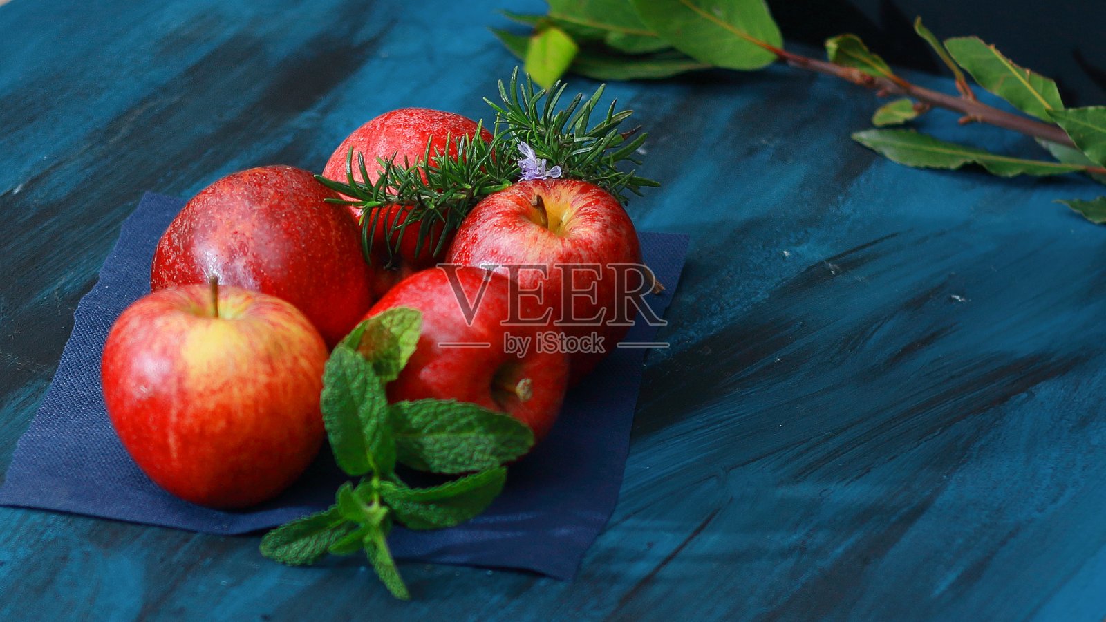 红苹果，带有迷迭香和薄荷叶照片摄影图片