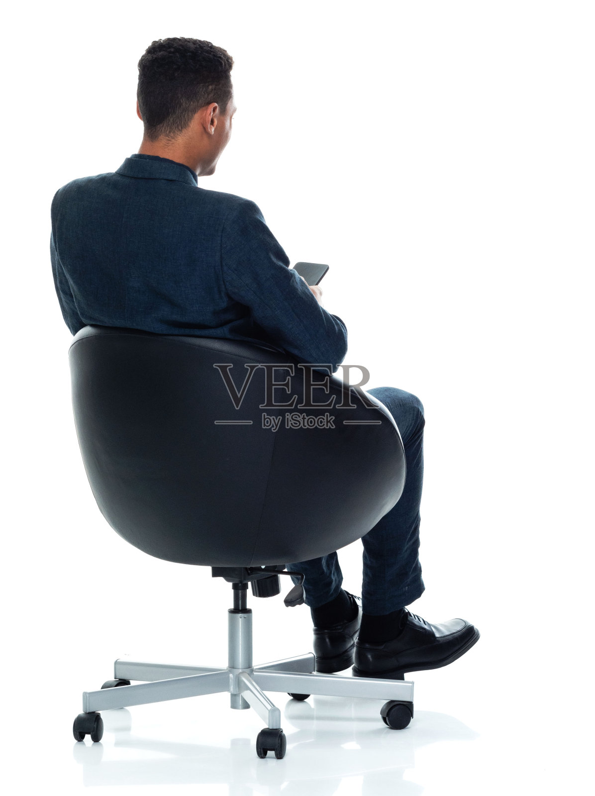 非裔美国人，年轻男性商务人士坐在白色背景下，穿着纽扣衬衫，使用智能手机照片摄影图片