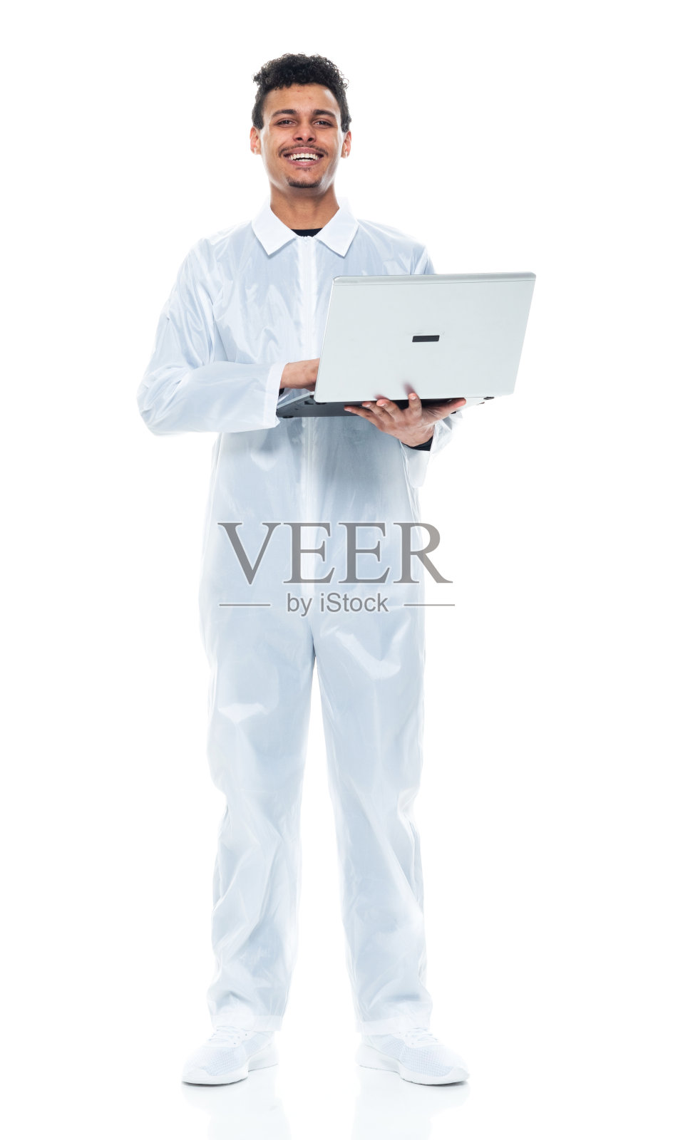 非裔美籍年轻男性画家穿着工作服站在白色背景前使用电脑照片摄影图片