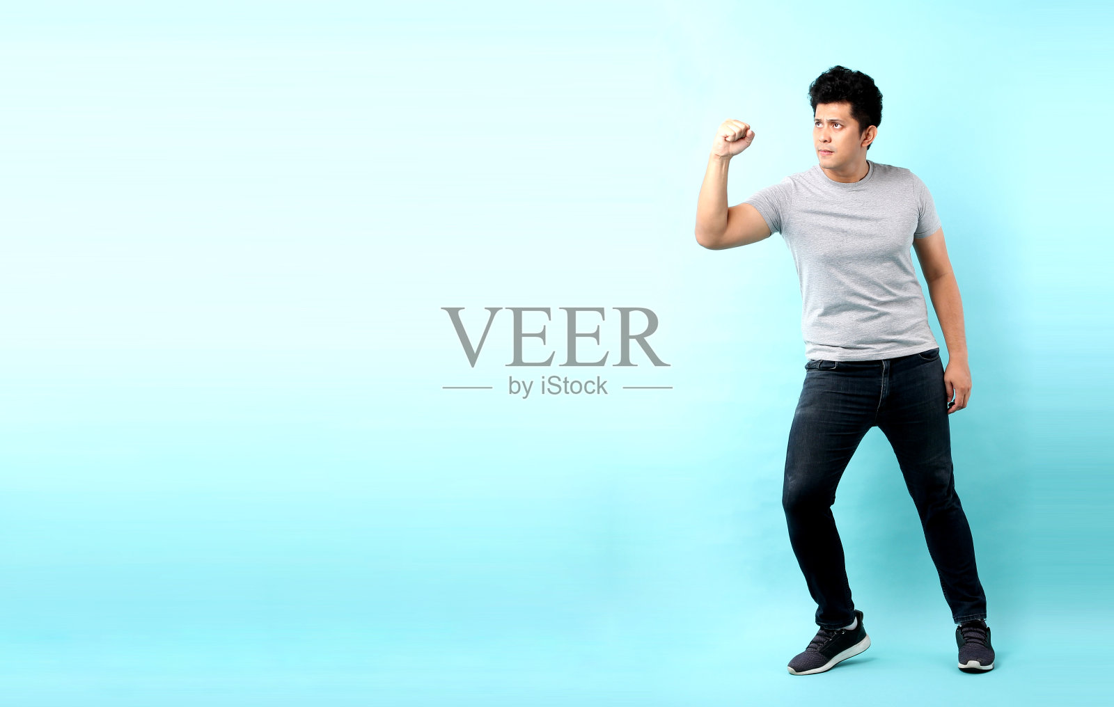 兴奋庆祝成功的亚洲男人全身像，蓝色背景照片摄影图片