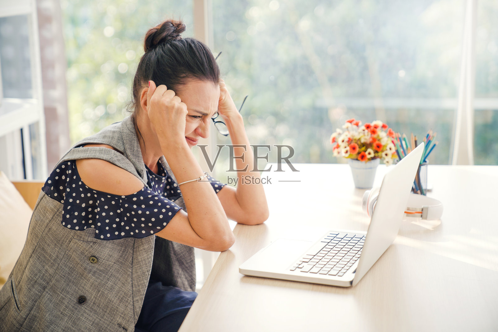 在家工作，在社交网络上发短信，感到有压力和疲惫的拉丁裔女人照片摄影图片