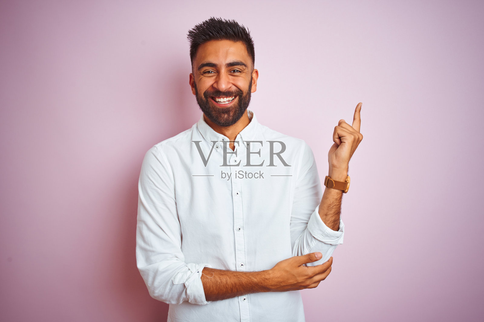 面带微笑，指向侧面的年轻印度商人照片摄影图片