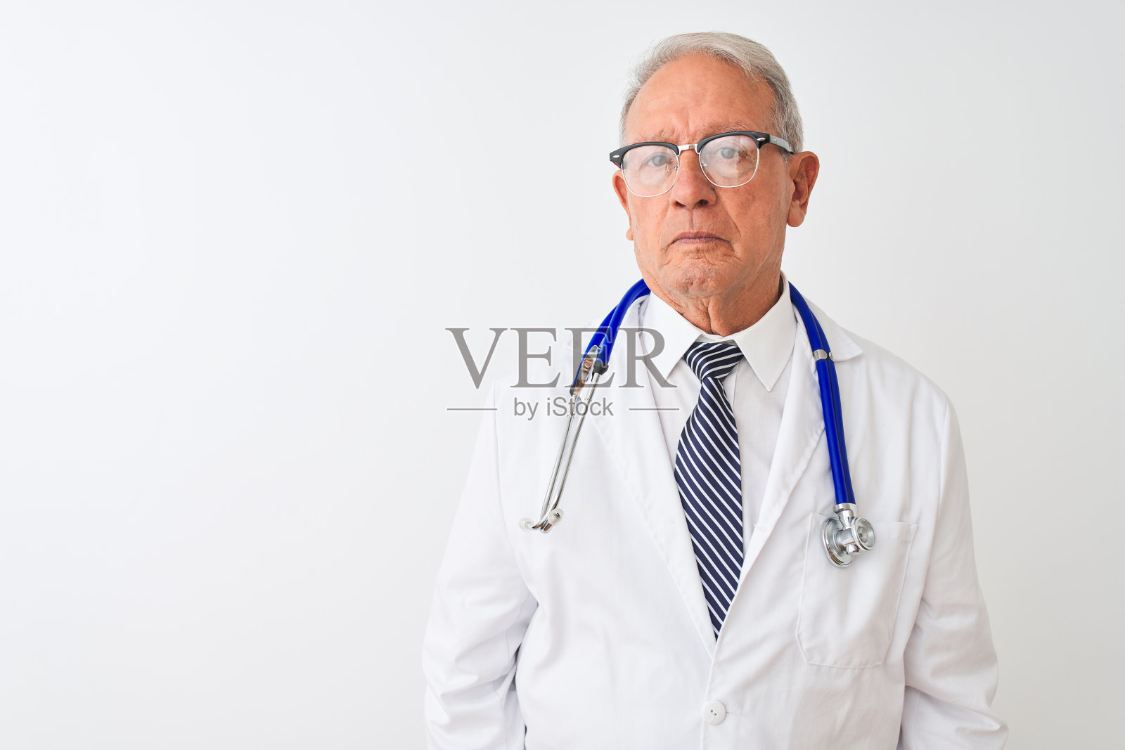 面色严肃、佩戴听诊器的年长灰发医生照片摄影图片