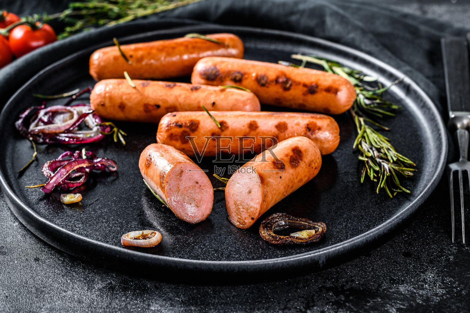 洋葱、大蒜和迷迭香炸鸡香肠。黑色背景。俯视图照片摄影图片
