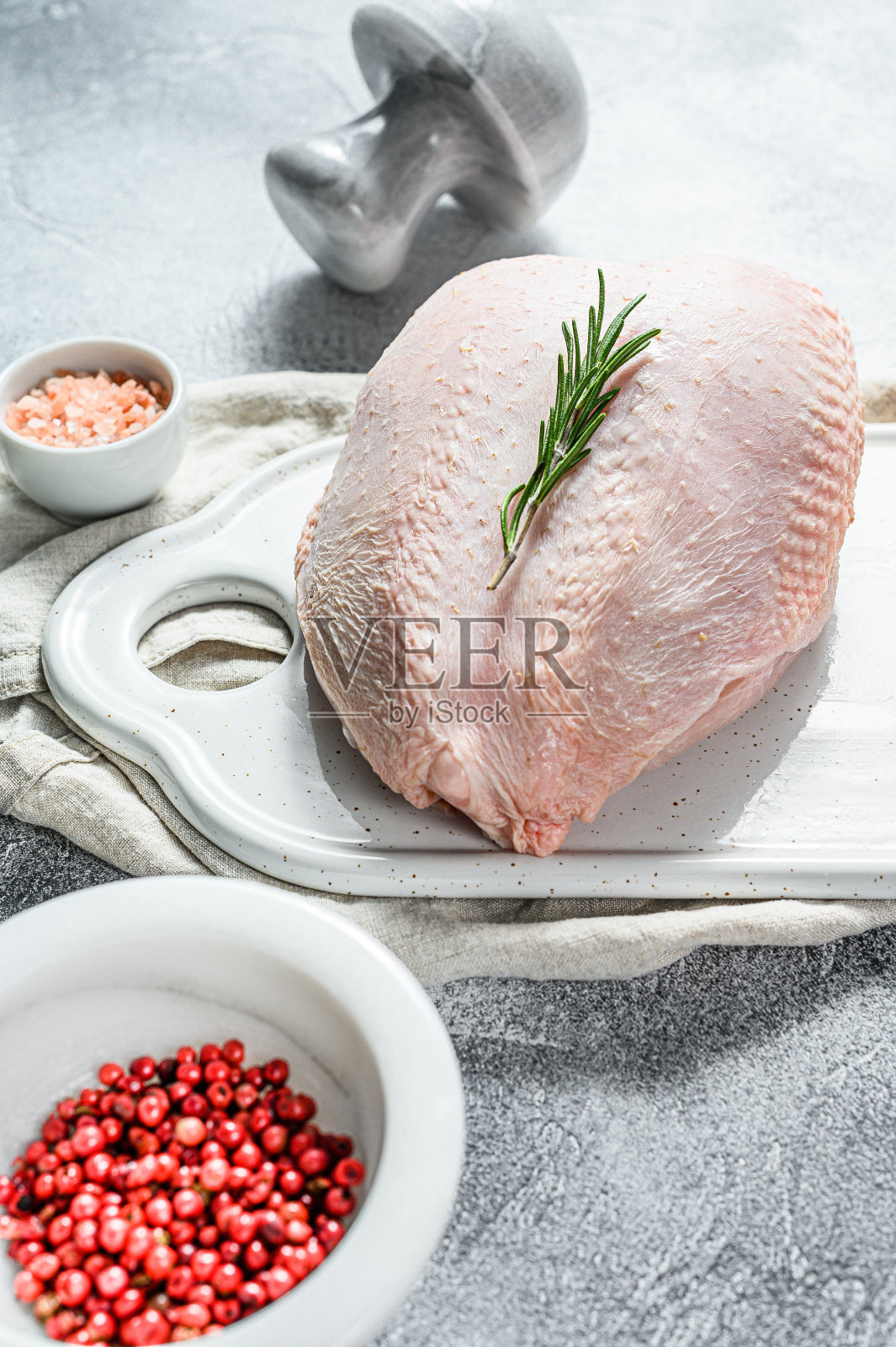 白菜板上放着生鸡胸肉。有机农场的鸟。带皮鲜鱼片。灰色背景照片摄影图片