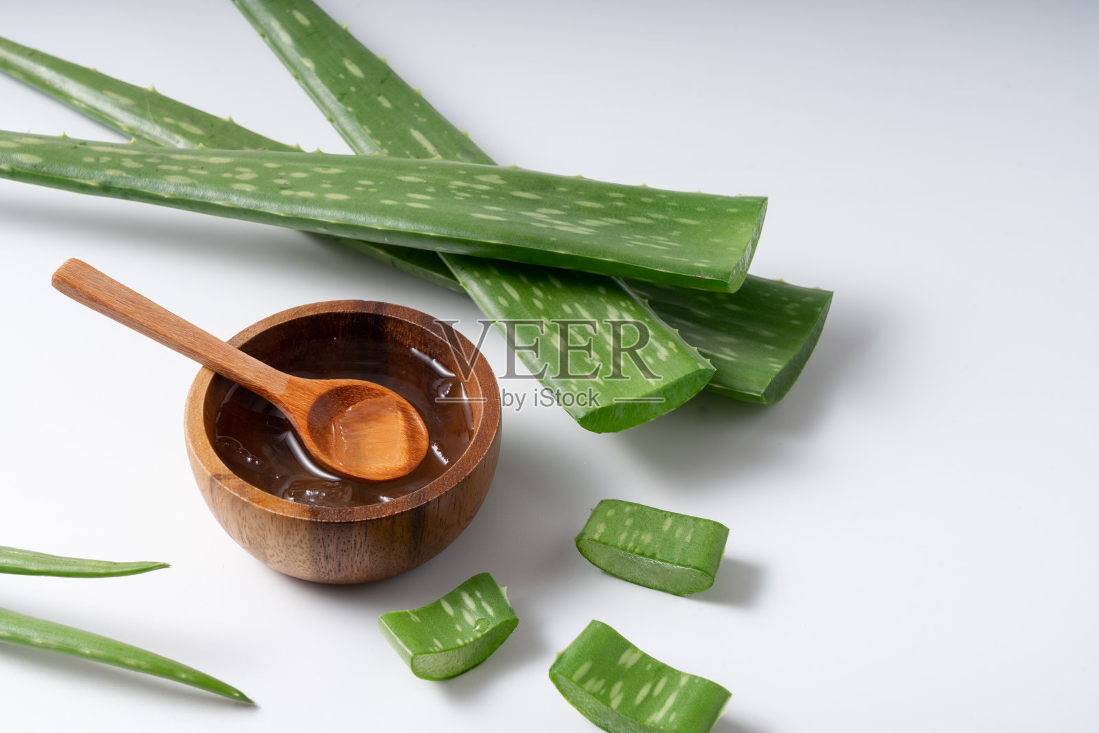 切芦荟茎和凝胶在木碗上白色背景，健康食品饮料和护肤美容理念，复制空间照片摄影图片